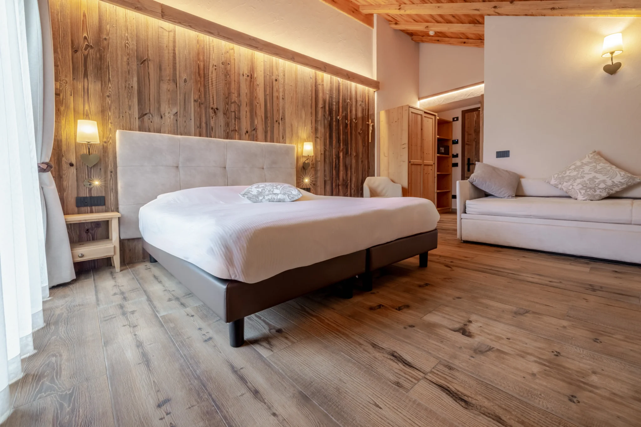 Camera da letto accogliente con pavimento in legno e arredamento rustico.