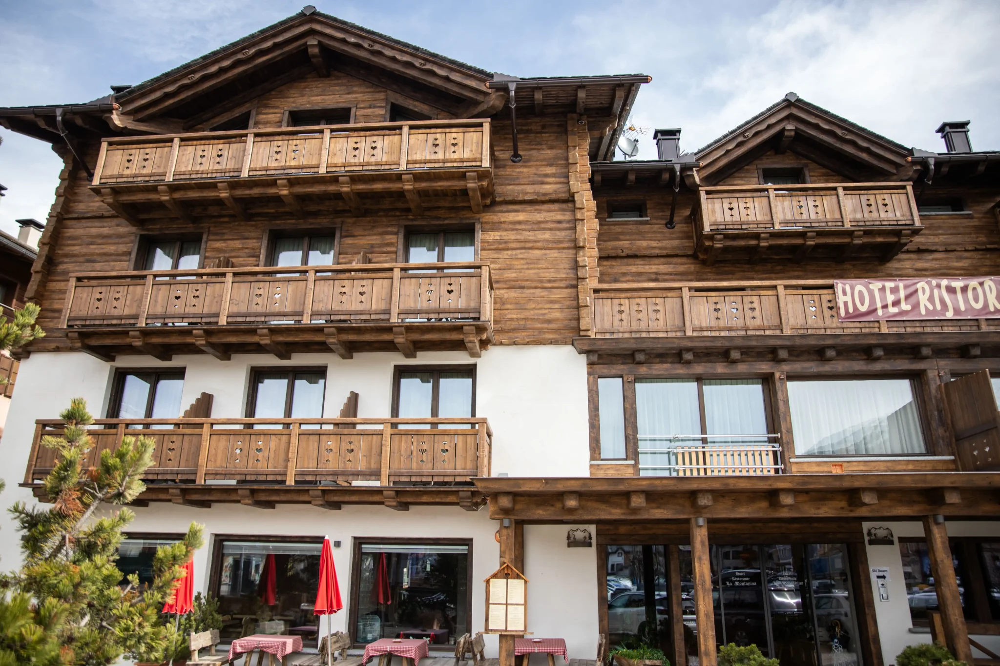 Facciata di un hotel in stile chalet di montagna con balconi in legno.