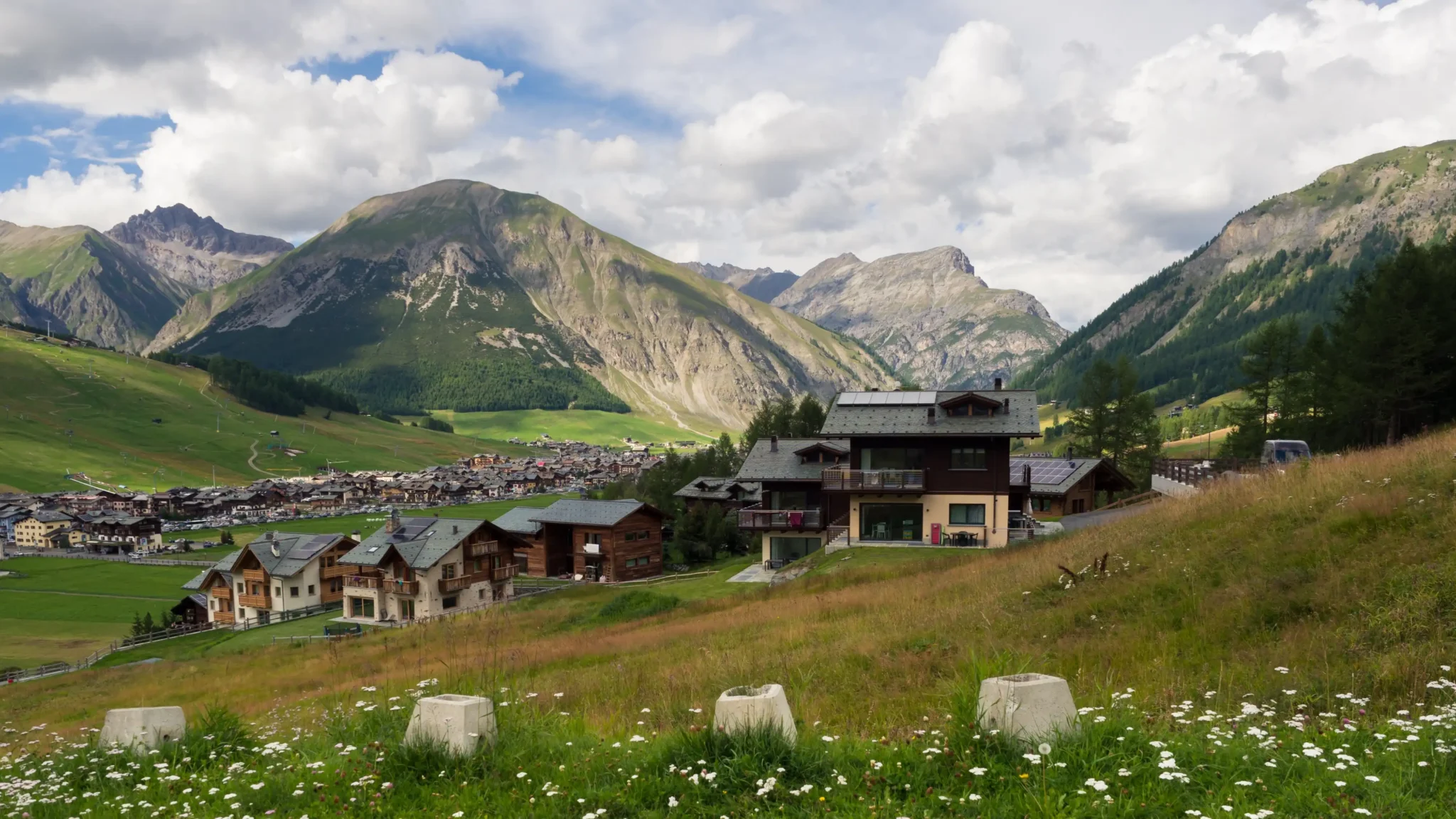 Paesaggio alpino con case e montagne sullo sfondo a Livigno.