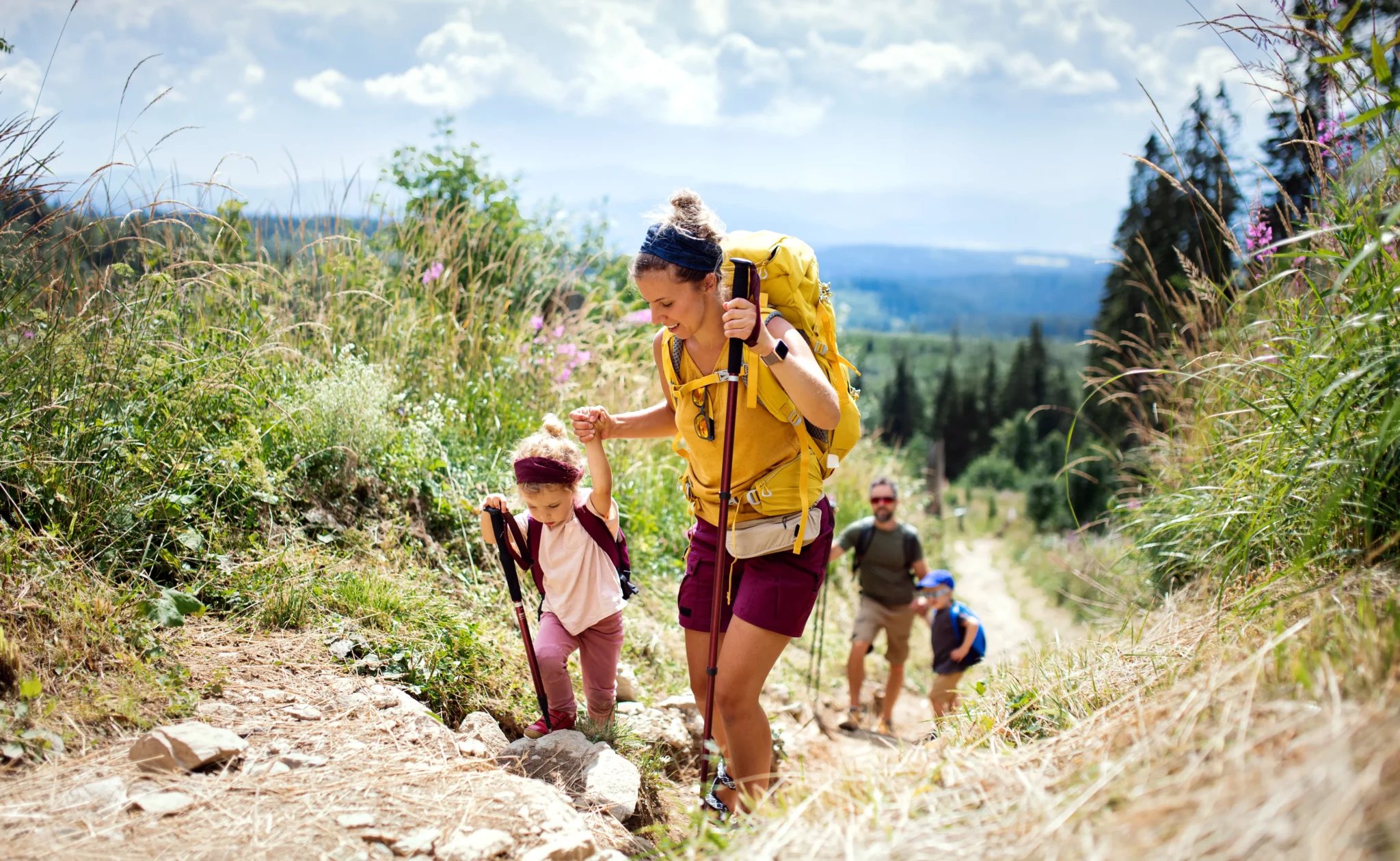 Una famiglia fa escursioni in montagna su un sentiero panoramico.