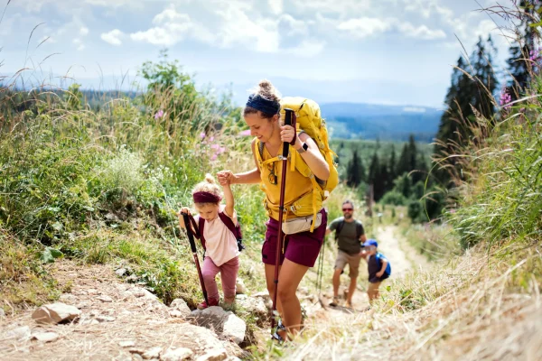 Una famiglia fa escursioni in montagna su un sentiero panoramico.